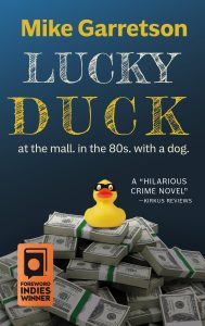 Cover of Lucky Duck, showing a rubber ducky in a bandit bask sitting on top of a pile of bound hundred-dollar bills.